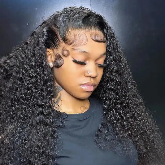 Woman with long, curly black hair wearing a black top against a dark background