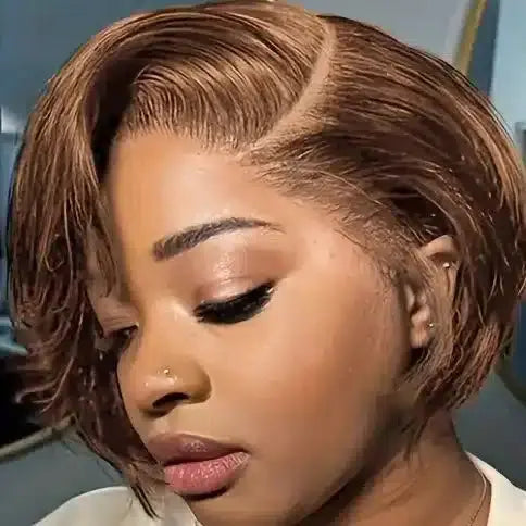 Woman with styled hair wearing a beige top against a blurred background